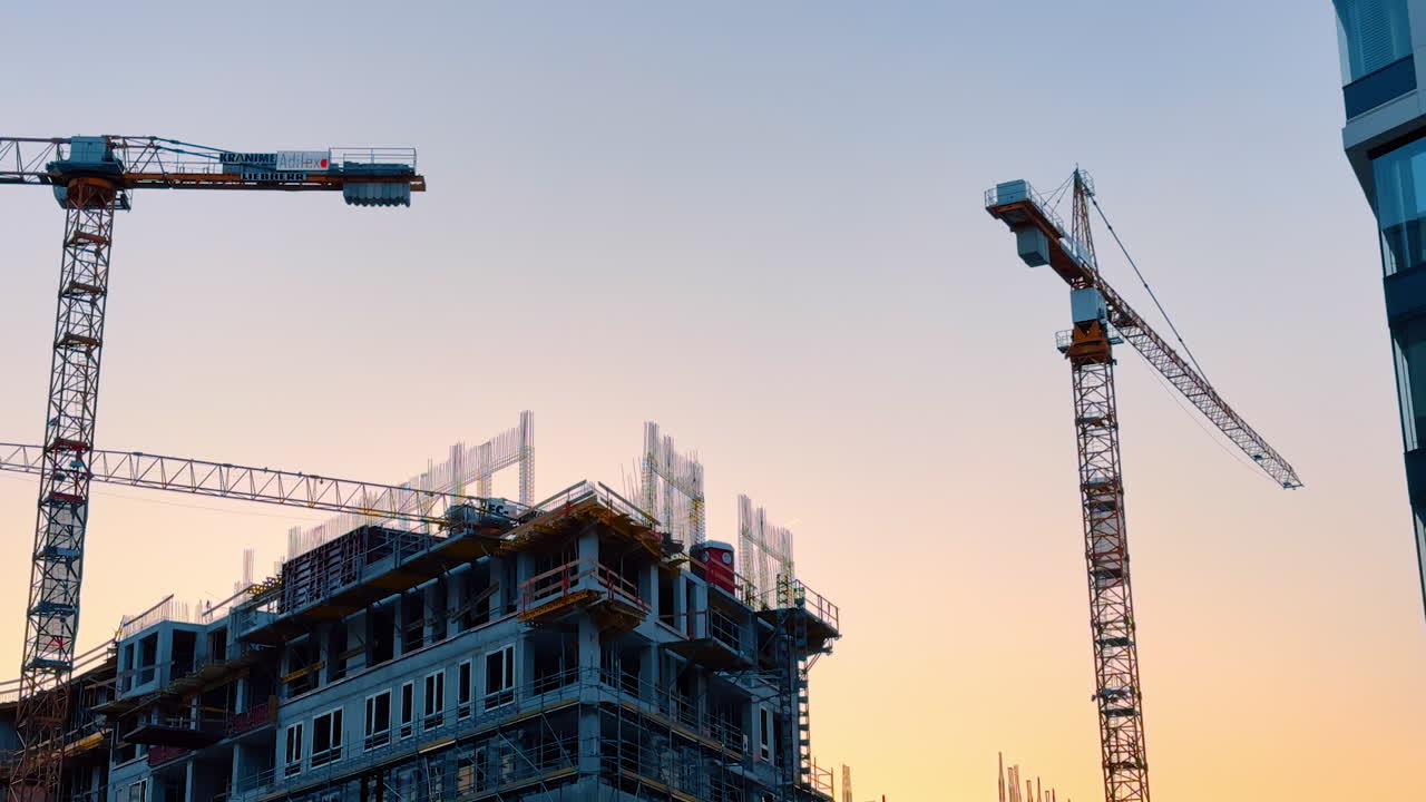 Bratislava, Slovakia, 2 June 2025: View on the modern high-rise building being constructed. Orange sky at sunset at backdrop. Bratislava, Slovakia