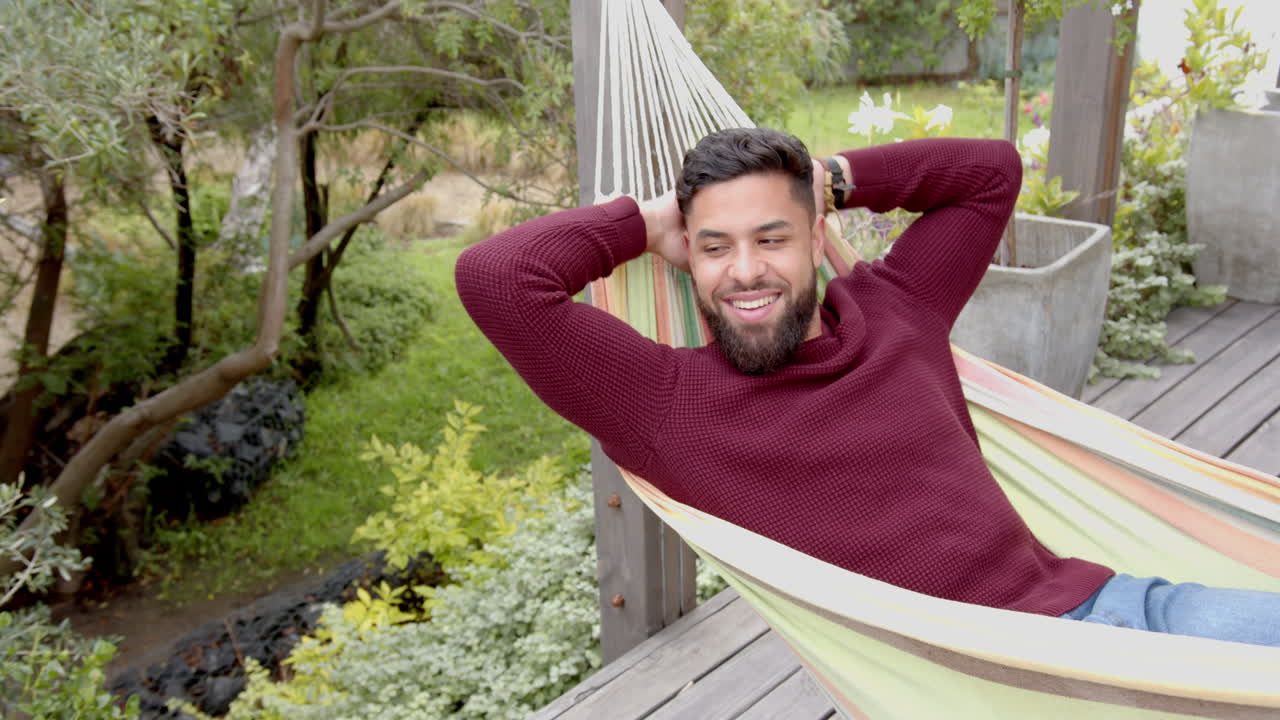 Relaxing in hammock, man smiling and enjoying outdoor leisure time