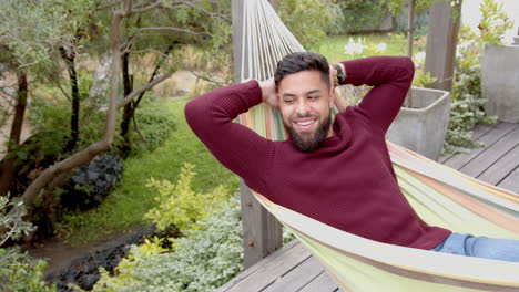 relaxing in hammock, man smiling and enjoying outdoor leisure time