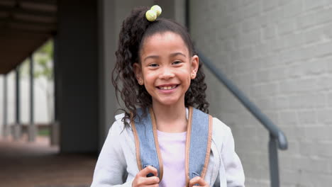 outside school, african american girl with backpack looking cheerful and excited