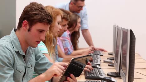 Estudiantes-Trabajando-En-La-Sala-De-Computadoras-Con-El-Profesor