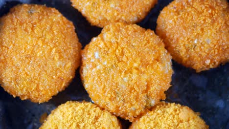 crispy breaded fish cakes frying in a pan