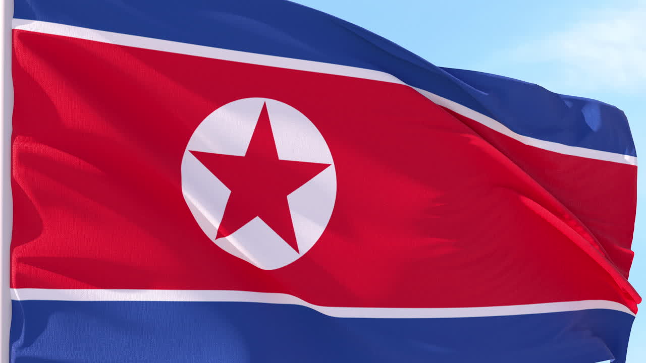 Bandiera della Corea del Nord che sventola al vento contro un cielo blu