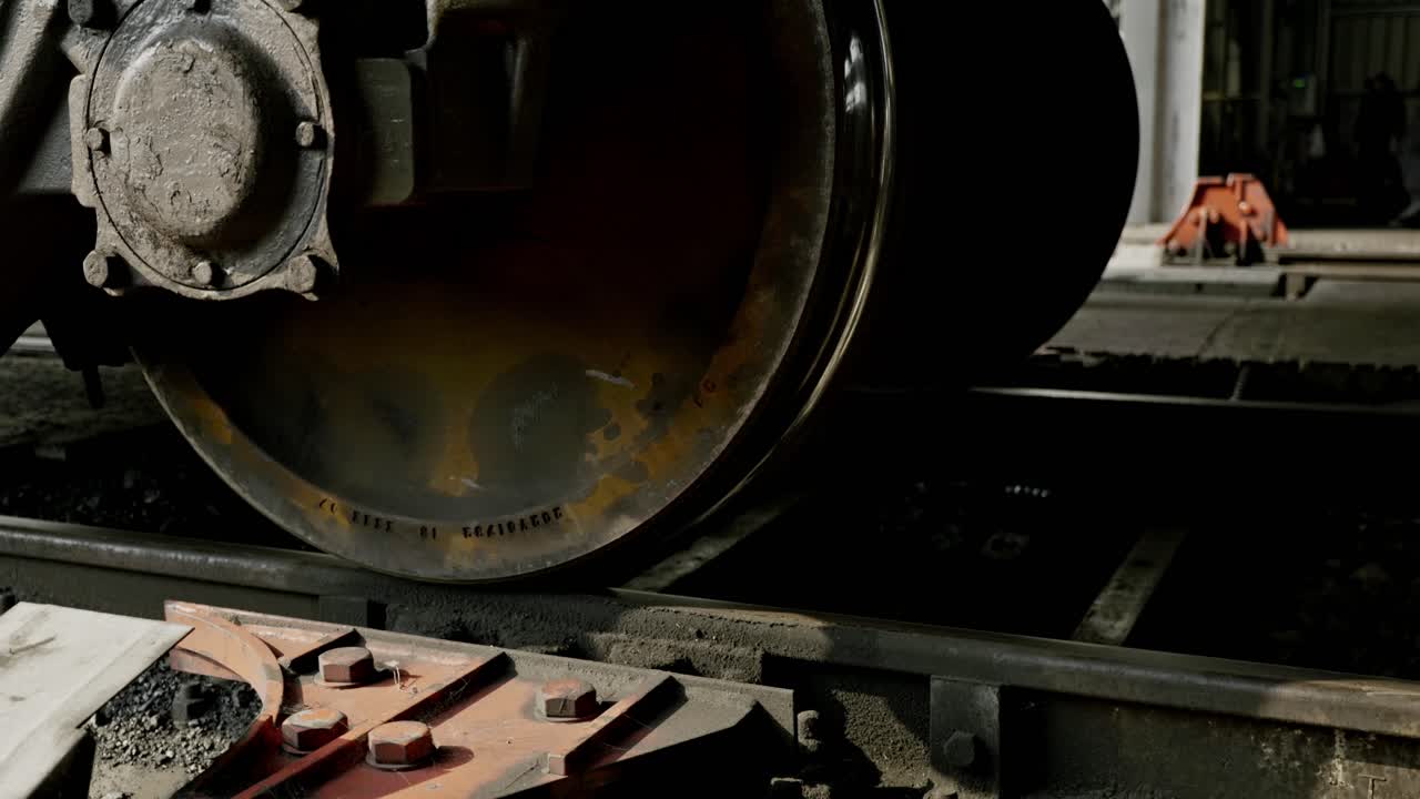 Vintage train wagon moving on industrial tracks, showcasing motion and history