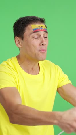 nervous man cheering for ecuador during a match looking away