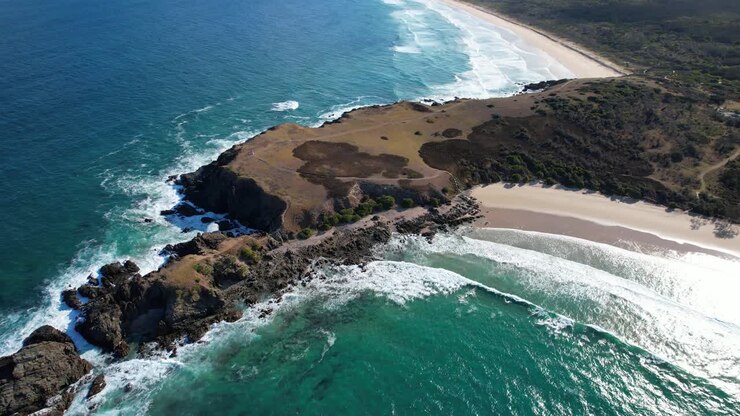 Onde che si infrangono sulla costa rocciosa del Promontorio Look At Me Now a Emerald Beach, Nuovo Galles del Sud, Australia