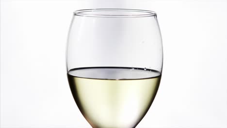 vaso giratorio de vino blanco fresco sobre fondo blanco