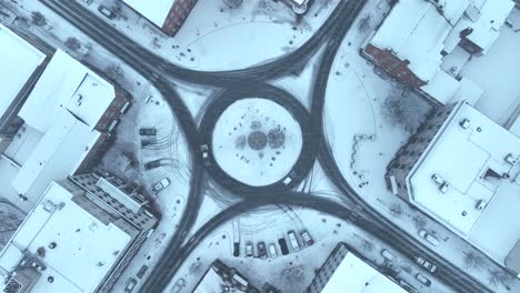 snowy aerial view of a small town square with roundabout roads in the usa