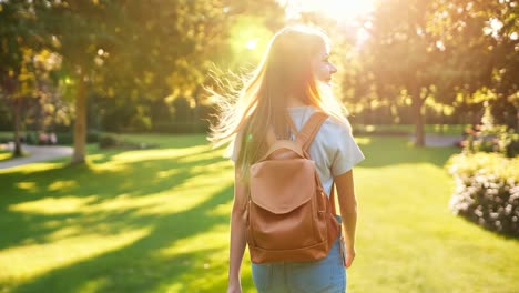 a woman walking in a park with a backpack