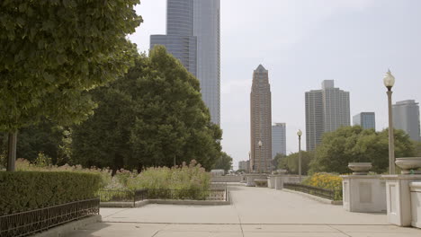 empuje lentamente por la acera de un parque en chicago cerca de ivy lawn hacia los edificios de la ciudad