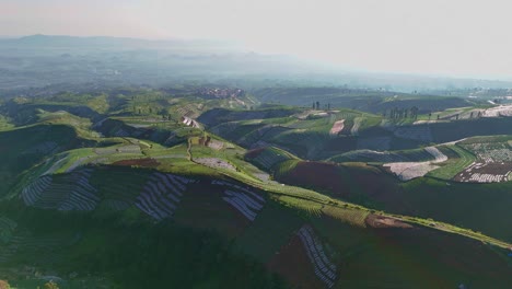 green patterns of vegetable plantations on the hills. aerial scenery rural landscape of agricultural field. indonesia rural landscape.