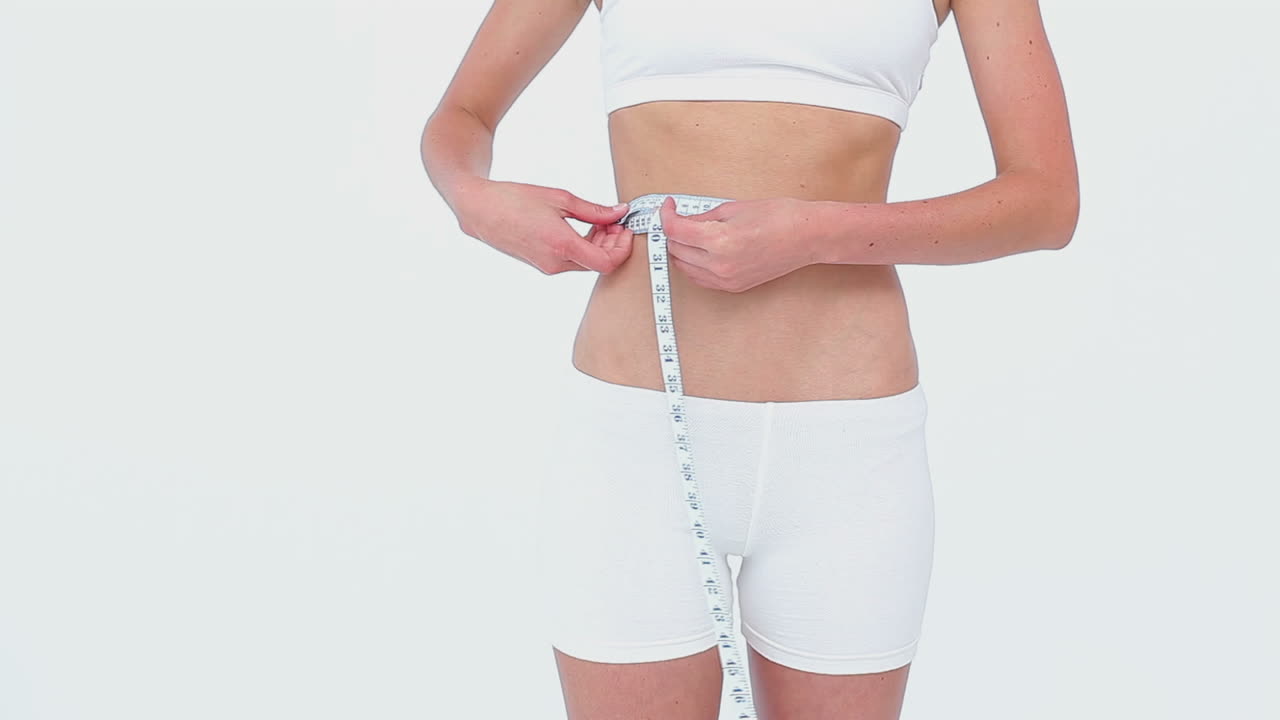 Woman using a tape on her waist