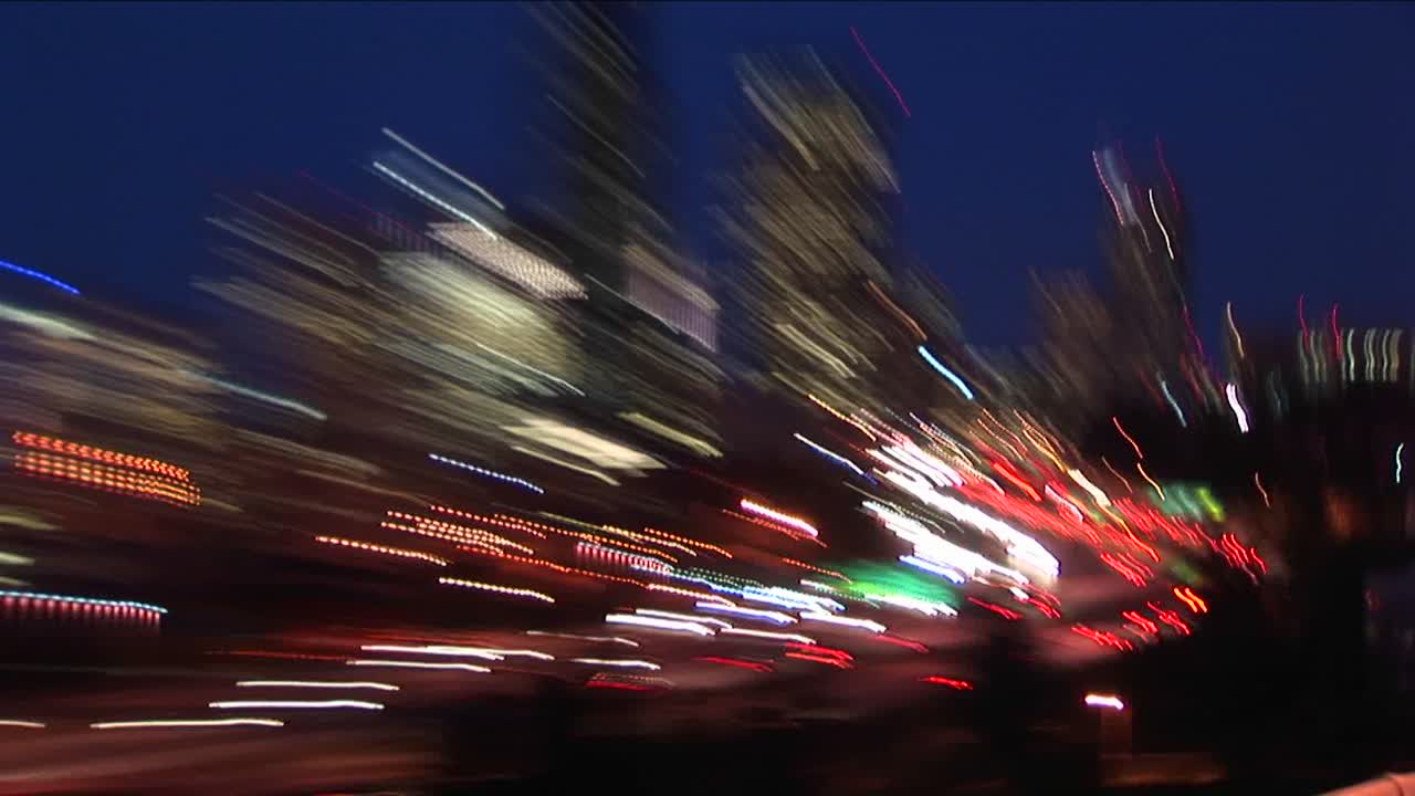 핸드헬드 카메라가 확대 및 축소되어 밤에 시애틀의 폭발적인 추상적 이미지를 생성합니다.