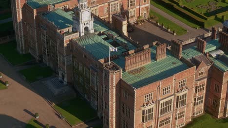 aerial view circling above hatfield house corner rooftop with flag blowing in the breeze