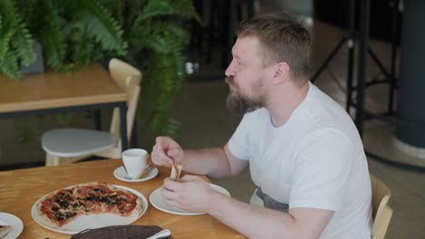 man eating pizza in a restaurant