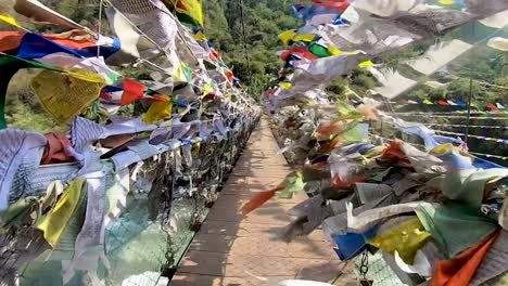 suspension iron bridge with many buddhist holy flags from different perspective