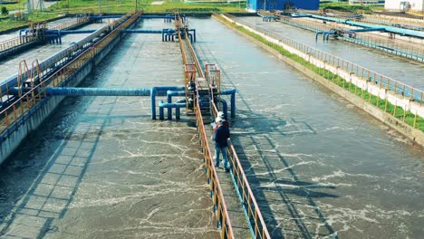 two businessmen walking through a large wastewater cleaning facility