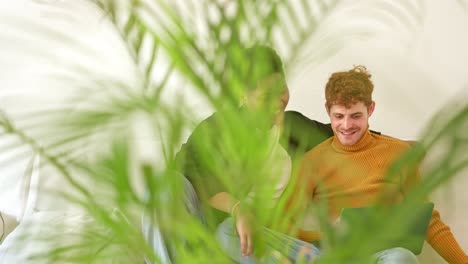 Happy LGBTQ+ Couple Relaxing with Laptop at Home
