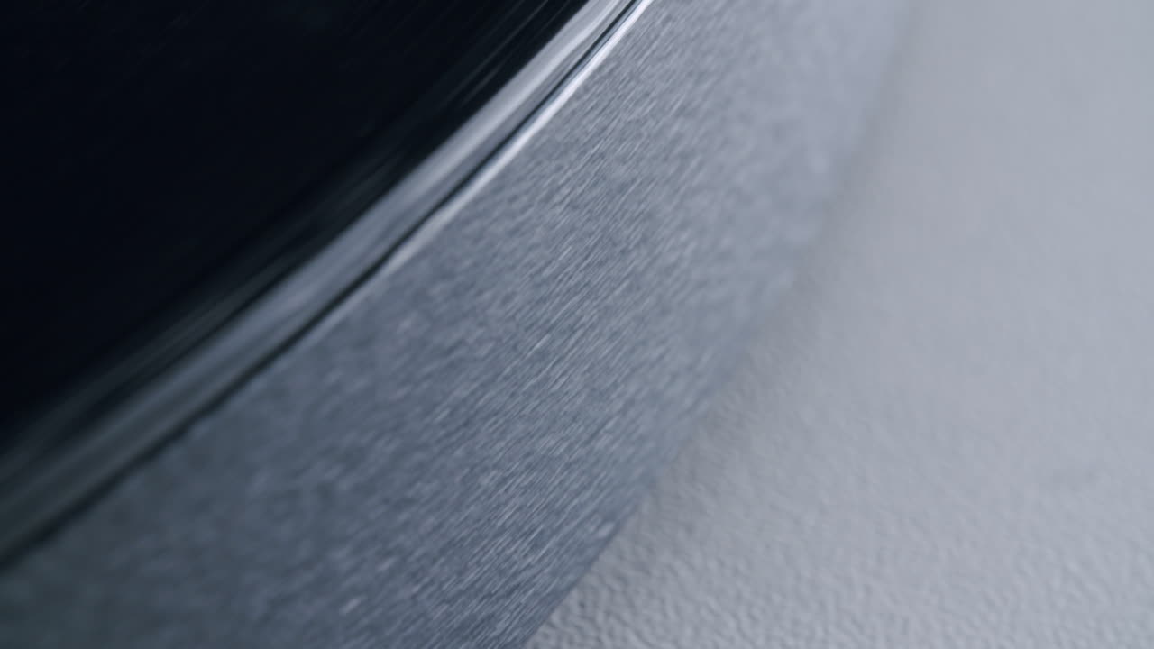 Close up shot of the side of a turntable with a spinning record. Abstract graphic shot with shallow depth of field