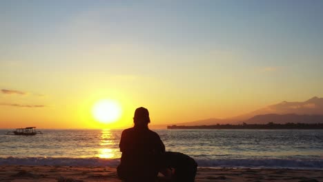 mujer joven meditando sentada en una tranquila playa exótica al atardecer mágico con sol amarillo en el cielo brillante, silueta de isla tropical, filipinas
