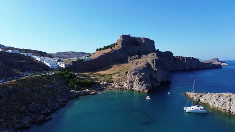 agios pavlos beach in rhodes, greece with acropolis of lindos, houses and mediterranean sea during the day filmed with the drone