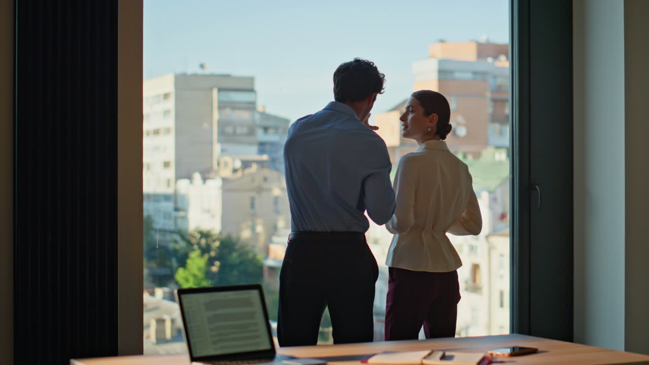 Colleague woman bringing coffee to thoughtful man looking office window