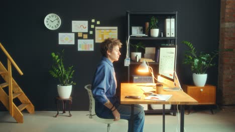 young businesswoman walking in office and working at desk