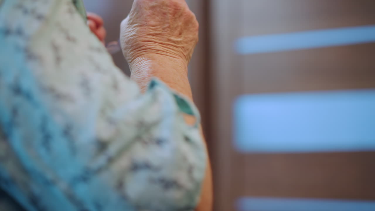 La nonna si aggiusta gli occhiali. Un'anziana nonna bianca sistema meticolosamente i suoi occhiali ogni mattina. Un'anziana donna bianca solleva e posiziona con attenzione gli occhiali durante la sua routine mattutina.