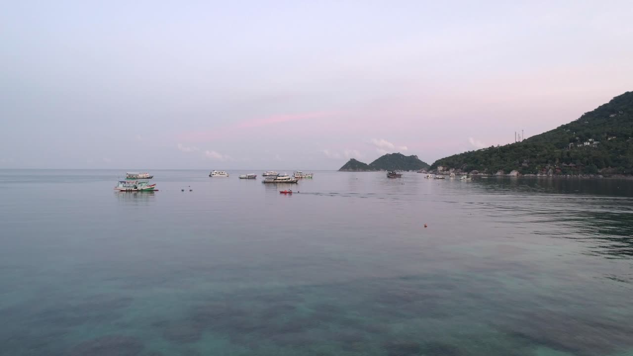 배경 에 배 와 섬 이 있는 평온 한 바다