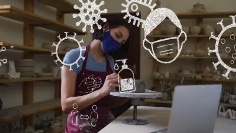 animación de iconos de covid 19 sobre mujer trabajando en un estudio de cerámica con máscara facial