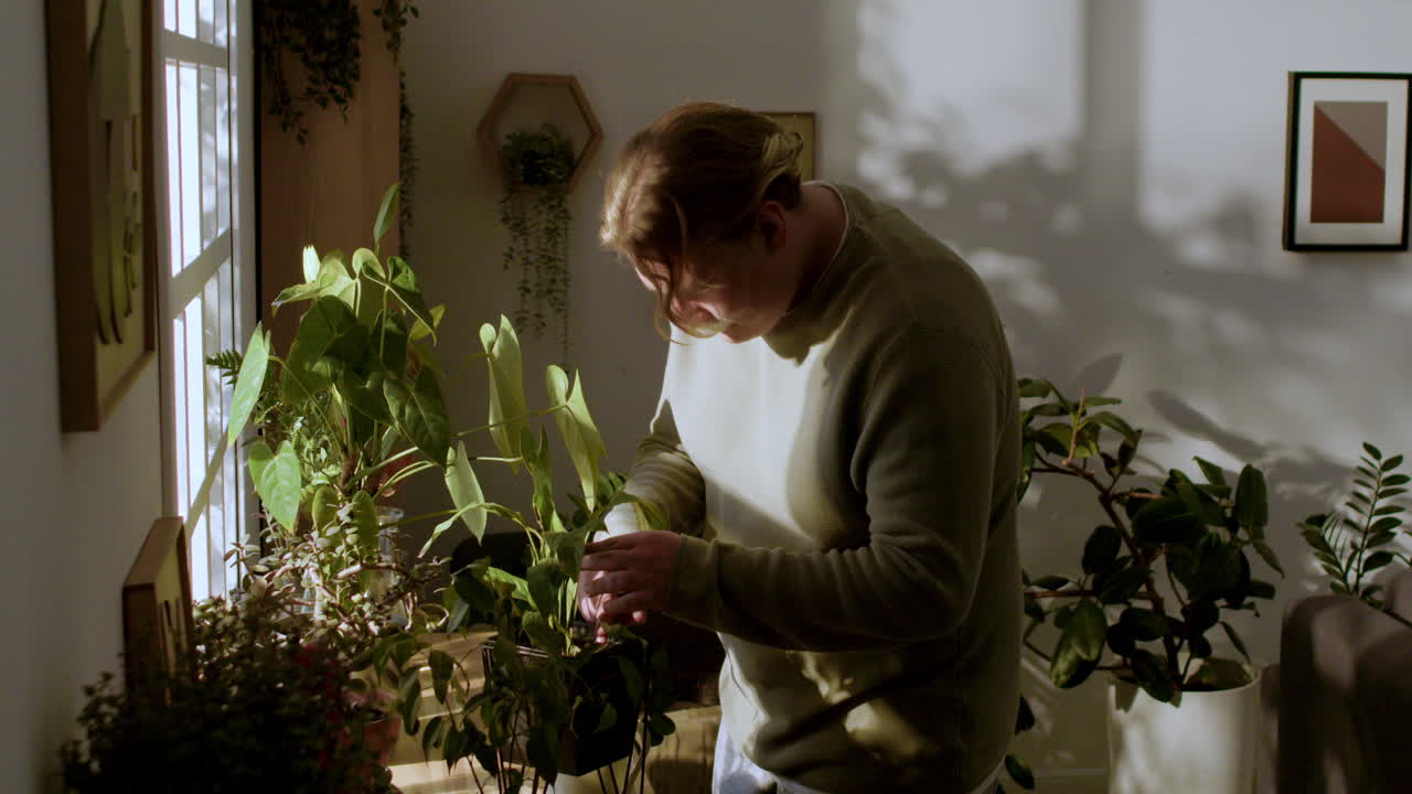 식물에 물을 주는 금발 남자