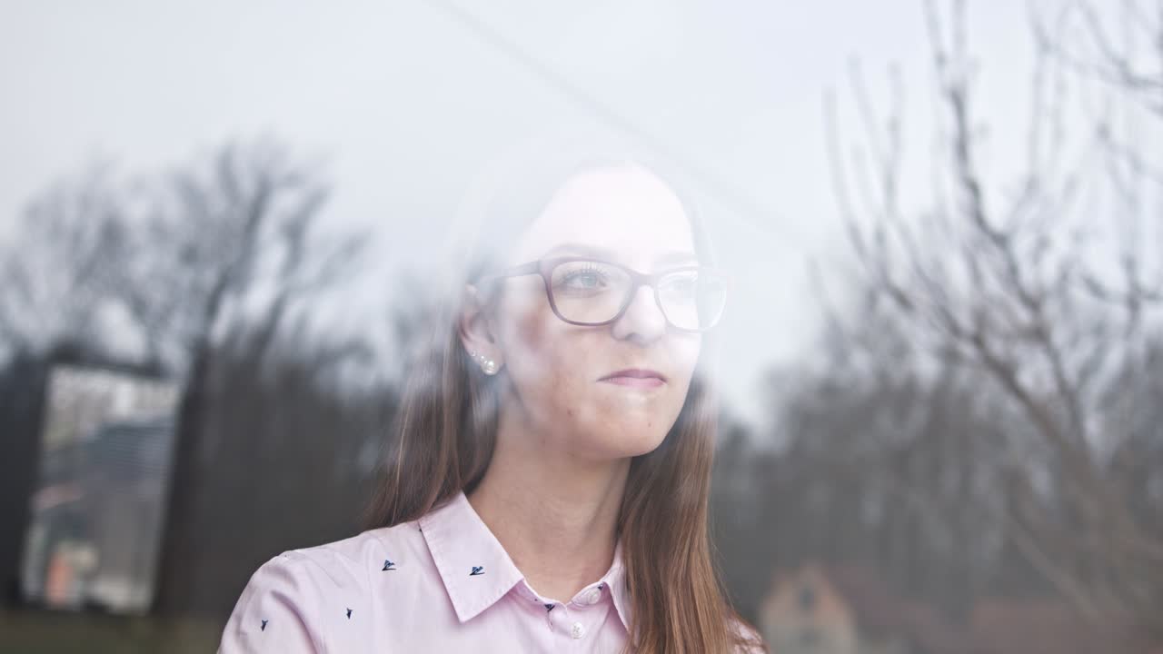 격리 중인 여성이 창밖을 바라보고 집에 머물고 자가 격리 중입니다.