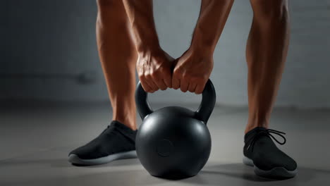 person gripping a kettlebell ready for a workout