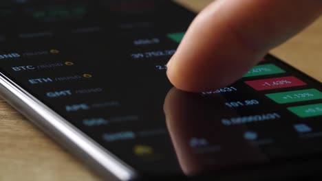 macro finger checking cryptocurrency chart on digital exchange on smartphone