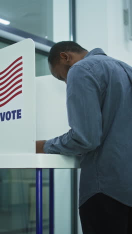 Caucasian-female-voter-puts-bulletin-in-box.-Diverse-people,-American-citizens-vote-for-future-president-in-voting-booths-at-polling-station.-Elections-Day-in-the-United-States-of-America.-Democracy.