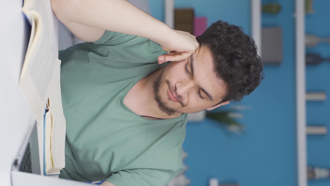 vídeo vertical de un estudiante varón se duerme mientras estudia.