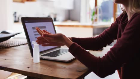 Woman-sanitizing-her-hands-at-home