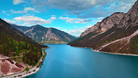 view on the calm surface of the mountain lake plansee on a daytime. drone footage among the beautiful rocks in tyrol, austria.
