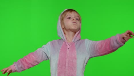 Child-girl-in-unicorn-pajamas-making-silly-funny-faces,-fooling-around,-showing-tongue-on-chroma-key