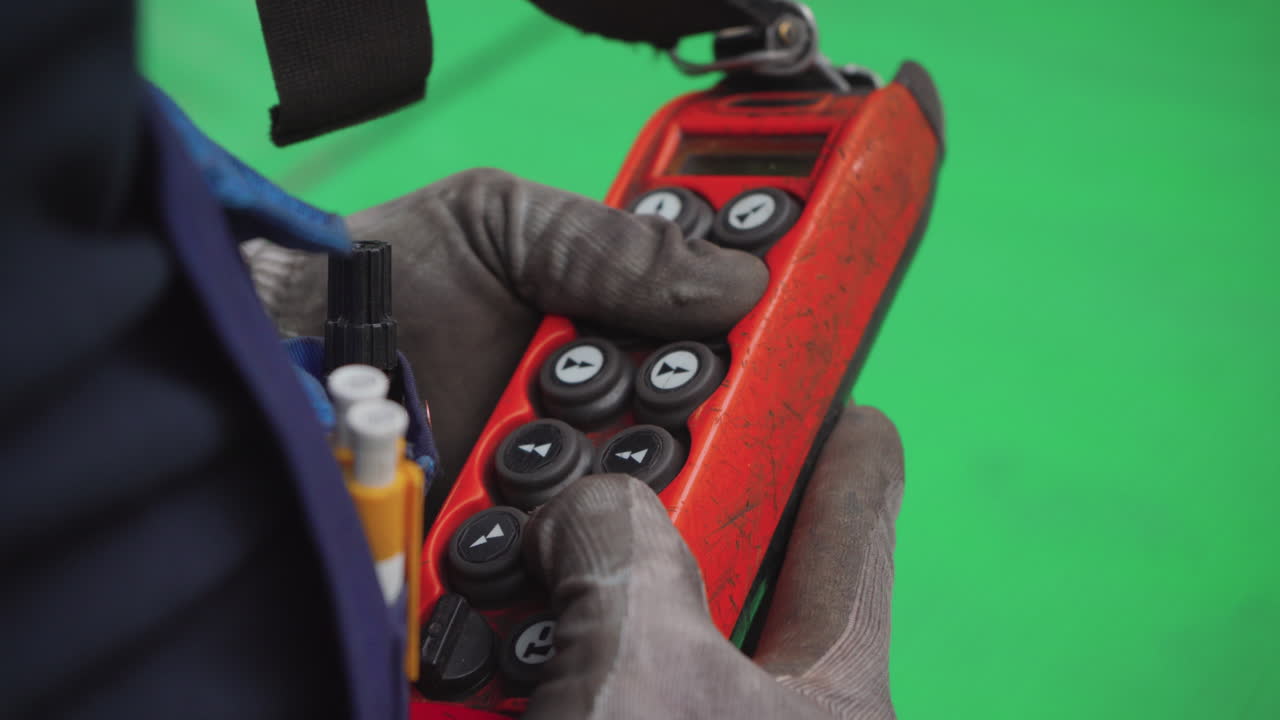 trabajador de fábrica que controla la maquinaria de elevación con controlador