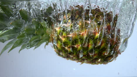 pineapple falling in water on white background