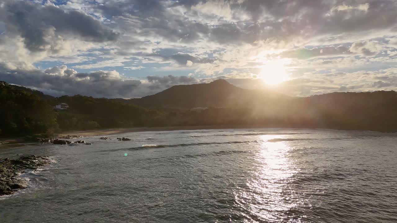 A serene sunset over Charlesworth Bay Beach with gentle waves and vibrant skies, captured in Coffs Harbour, Australia