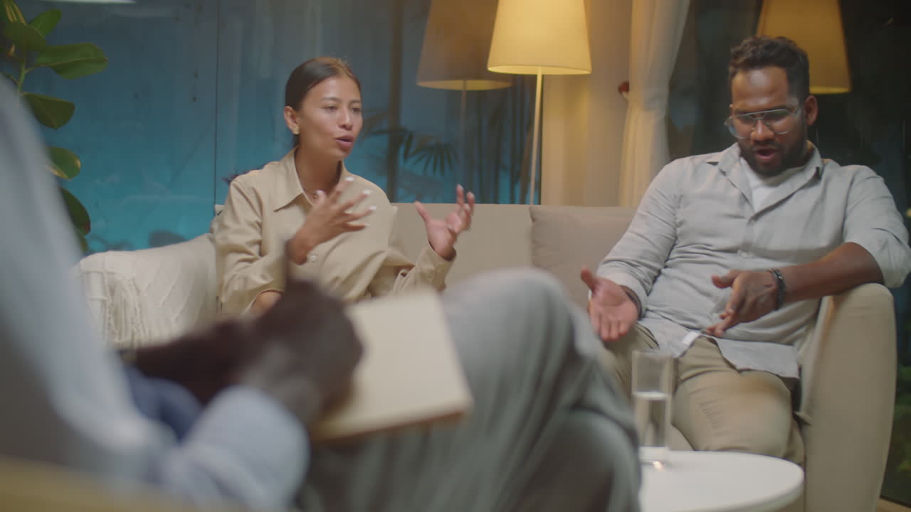 Couple Fighting on Therapy Session as Psychologist Taking Notes