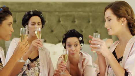 Four-women-toasting-champagne-glasses-on-the-bed-4K-4k