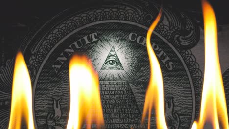 pyramid on a banknote of 1 us dollars bill with glowing freemasons eye on top on fire in flames. conceptual 4k slow motion raw video. financial crisis idea, conspiracy theory.