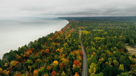 aerial shot of a road running parallel to lake superior in full fall color