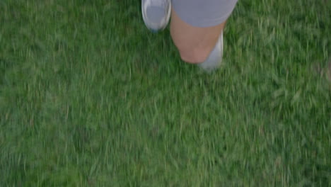 man walking in park wearing sneakers strolling casual on grass top view