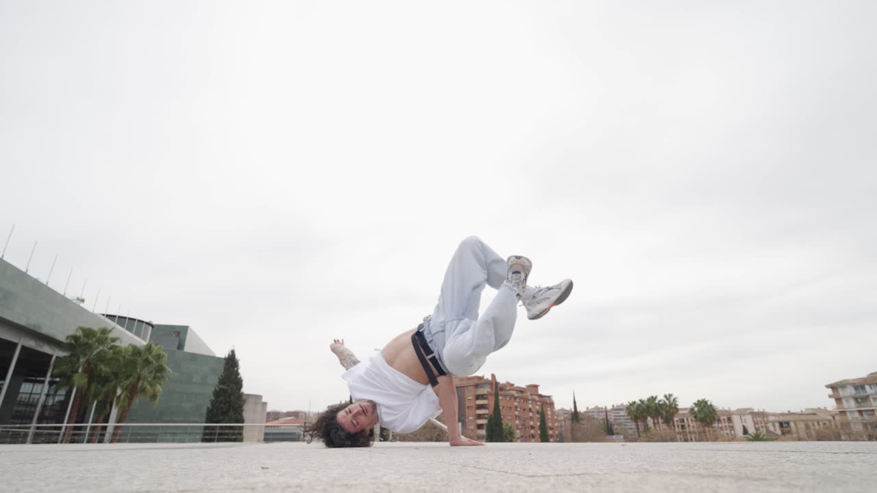Breakdancer performing acrobatics outdoors in urban setting