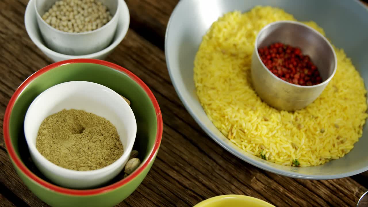 arroz amarillo con varias especias en una mesa de madera 4k
