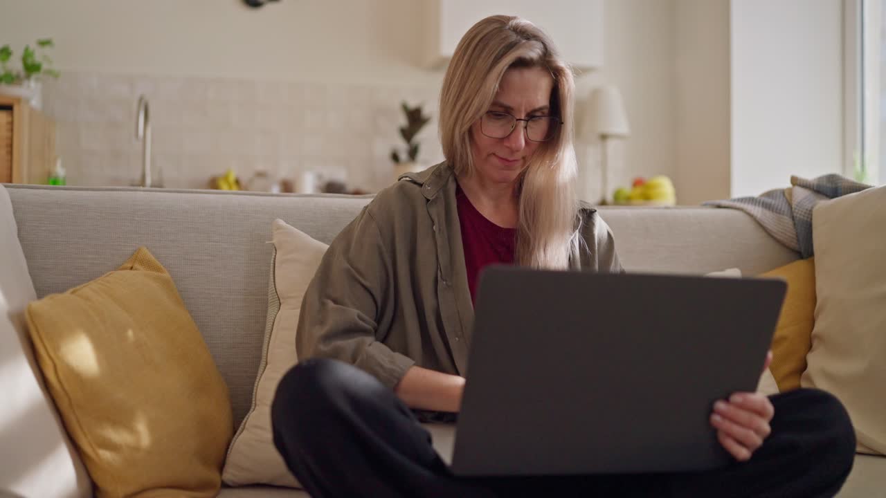 mujer trabajando desde casa en una computadora portátil